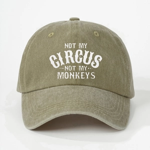 Detailed texture of olive green washed cotton cap with Not My Circus printed text