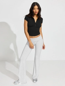 Full body studio shot of black short-sleeved polo crop top and grey flared gym trousers