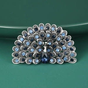 Macro detail of a vintage peacock brooch featuring sparkling blue rhinestones