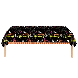 Detail view of a Halloween tablecloth featuring pumpkins, skulls, and Happy Halloween text