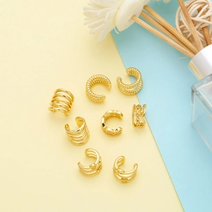 Set of eight gold-plated geometric ear cuffs featuring spiral and chain textures