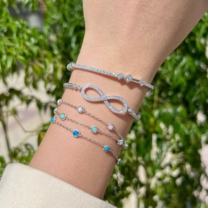 Detail of S925 silver Mobius bracelets with shimmering zircon and opal stones on wrist