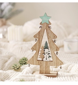 Detail der hölzernen Weihnachtsbaum-Deko mit Schneemann-Silhouette und Silberglöckchen