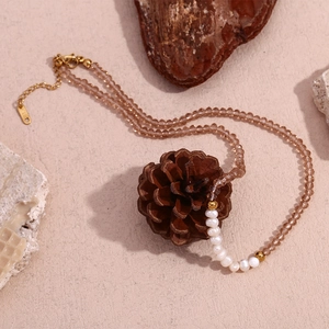 Detail of handmade necklace with brown crystal beads, freshwater pearls, and gold clasp