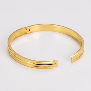 Elegant gold stainless steel open bangle with parallel grooves in a minimalist style
