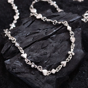 Silver poker suits necklace with heart and spade charms on dark charcoal stone