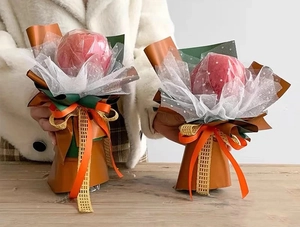 Detail of Christmas apple gift bouquet with red fruit and lace wrapping paper