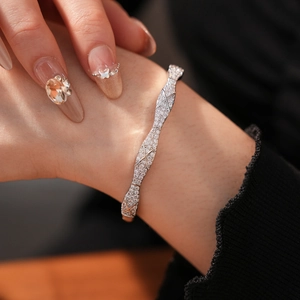 Close-up of quilted pattern silver bangle with pavé zircons on woman's wrist
