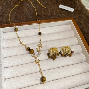 Detailed view of tiger eye stone jewelry set with star and moon elements in a gift box
