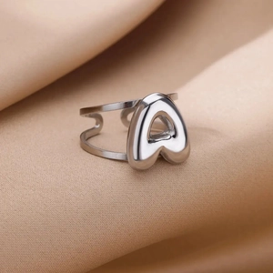 Macro detail of a silver bubble letter A stainless steel adjustable open ring on silk