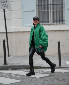 Street style shot of an oversized green bomber jacket with black platform lace-up boots