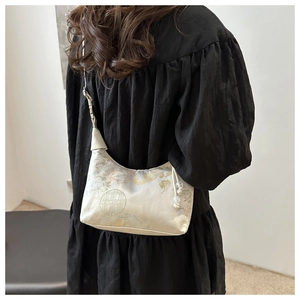 Detail of embroidered silk bucket bag with floral patterns and traditional tassel