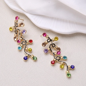 Detail of long Christmas tree earrings with colorful rhinestones on golden alloy