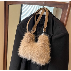 Close-up of khaki plush faux fur bag with brown leather strap and silver metal hardware