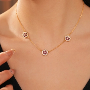 Dettaglio di una collana a fiori placcata oro 18 carati con zirconi indossata da modella