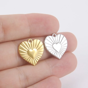 Gold and silver heart-shaped stainless steel pendants with radiant sunburst texture