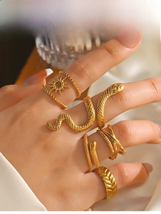 Detailed close-up of golden vintage snake rings and boho sunburst ring set for women