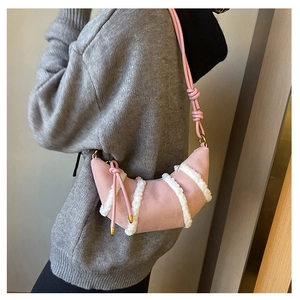 Detailed texture of pink suede and white faux fur on a crescent moon crossbody bag