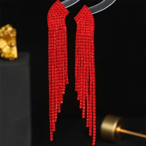 Macro detail of elegant long red rhinestone tassel earrings on a black background