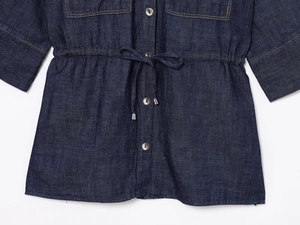Dettaglio del set in denim blu scuro con coulisse in vita e bottoni metallici