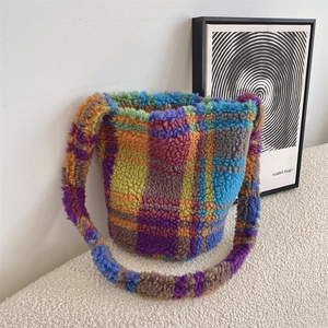Close-up of colorful checkered plush bucket bag with soft sherpa texture and metal clasp