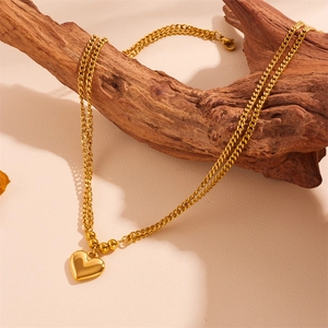 Set collana con ciondolo a cuore dorato e catena a doppia fila su ramo di legno