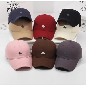 Close-up of colorful cotton baseball caps with delicate elephant embroidery detail