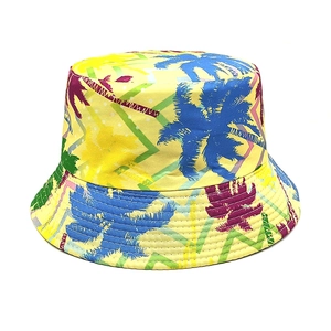 Détail d'un chapeau bob jaune avec imprimés de palmiers colorés et motifs géométriques