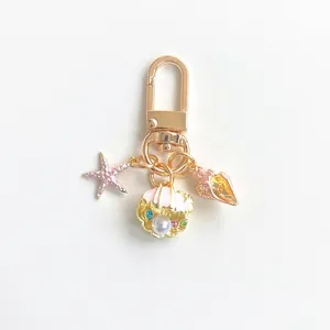 Marine ocean keychain with pink glitter starfish and pearl shell charms in gold finish