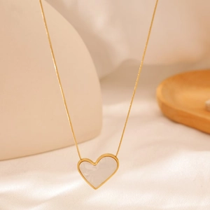 Detailed close-up of 18K gold heart necklace with white mother-of-pearl inlay