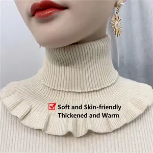 Detail of cream knit faux collar featuring ribbed high neck and ruffled hem texture