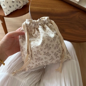 Detail of floral drawstring cotton pouch showing small brown flowers on cream fabric