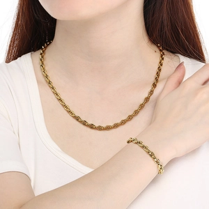 Ensemble collier et bracelet en maille grain de café dorée porté par un modèle