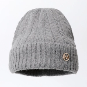 Close-up of grey mohair knit beanie featuring a fuzzy texture and gold rhinestone M logo