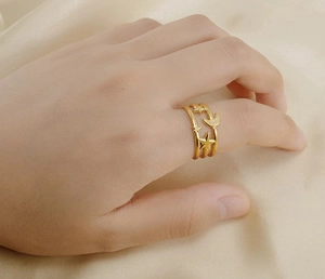 Detail of 18K gold-plated stainless steel ring with star and moon charms on a model finger