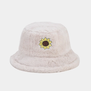 Dettaglio del cappello alla pescaiola in peluche beige con ricamo di girasole giallo