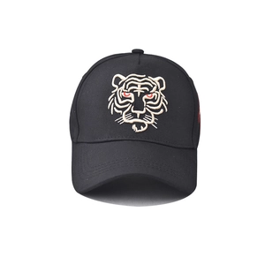 Close-up of intricate tiger head embroidery with red eyes on a black cotton baseball cap