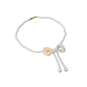 Elegant pearl necklace with bow design and double pearl pendants on a white background