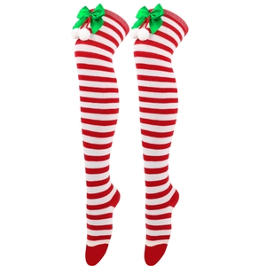 Detail of red and white striped Christmas over-knee socks with green bow and white pom-pom