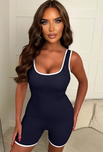 Deep blue sleeveless athletic romper with white trim shown in a professional studio setting