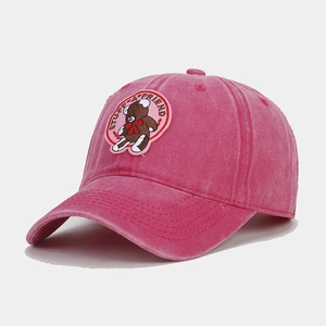 Detail of embroidered brown bear patch on washed pink cotton vintage baseball cap
