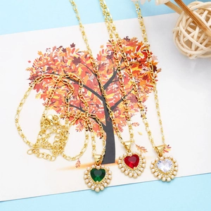 Detailed view of heart-shaped pendant necklaces with colorful stones and pearl accents