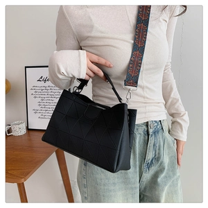 Detail of black geometric quilted tote bag with bohemian pattern wide strap