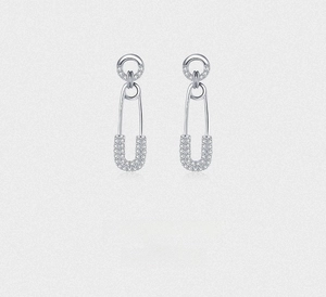Macro shot of silver safety pin earrings with sparkling zircon paving on s925 metal