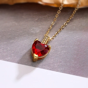 Close-up of red heart zircon pendant necklace in gold plating with elegant details