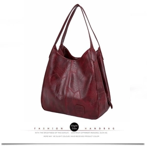 Close-up of wine red faux leather tote bag showing vintage cracked texture and handles