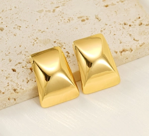 Macro shot of 18k gold plated stainless steel rectangular earrings on beige stone