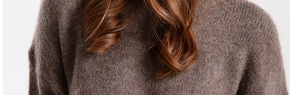 Detailed macro shot of dark brown knitted hat fabric with soft mohair wool texture