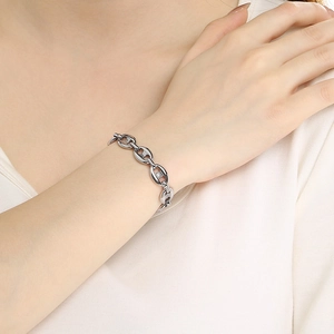 Detailed view of silver titanium steel anchor chain bracelet on wrist of a fashion model