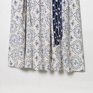 Robe à fleurs bleue avec ceinture montrant un gros plan de la texture de l'ourlet plissé